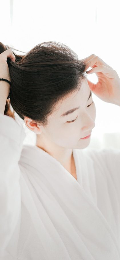 直播伴侣 App 美颜调节界面，左侧是实时人像预览，右侧排列着磨皮、瘦脸、亮度、色温四个滑杆，数值清晰可见